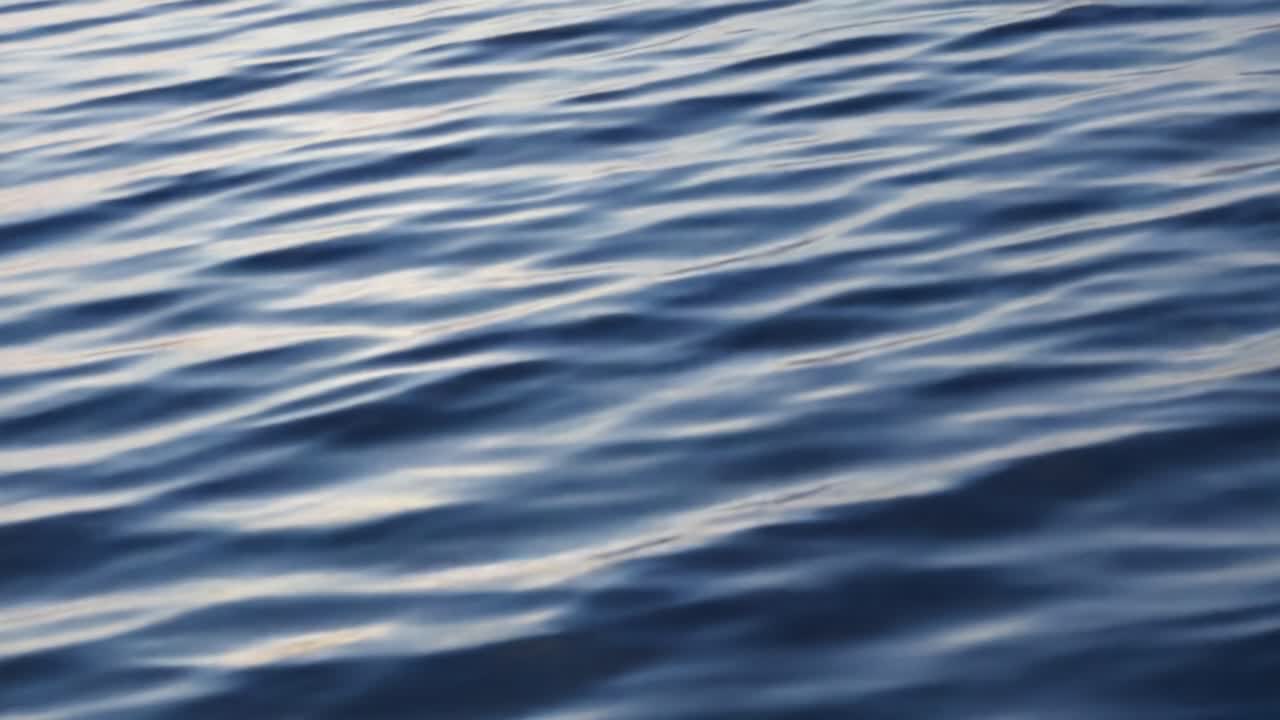 A Serene View of Gentle Water Waves Reflecting Light, Capturing the Tranquility and Beauty of Nature in a Calming Blue Palette