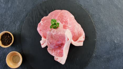 sirloin chop and bowls of spices on concrete background