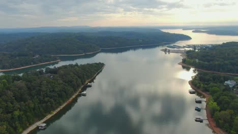 aerial view of flight up lake finger toward marina with the light of sunrise on the horizon