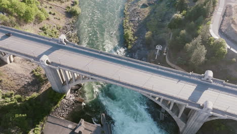a bridge crosses over a fast-moving river in spokane. the water swirls below with strong current
