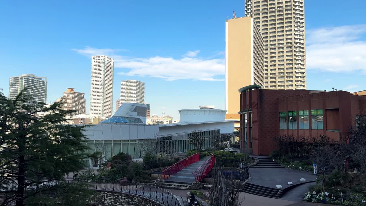 현대적인 건물을 배경으로 한 도시 공원, 은 하늘, 울창한 초록색, 그리고 빨간 다리, 낮 시간, 평온한 도시 분위기