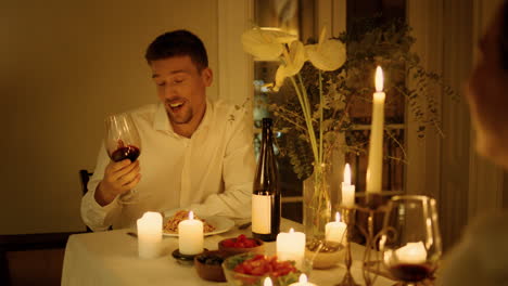 Gesturing-guy-chatting-romantic-dinner-closeup.-Sweethearts-drinking-wineglass