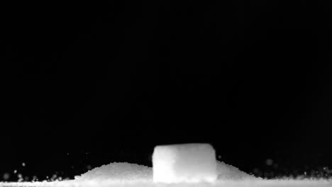 sugar cube falling on pile of sugar