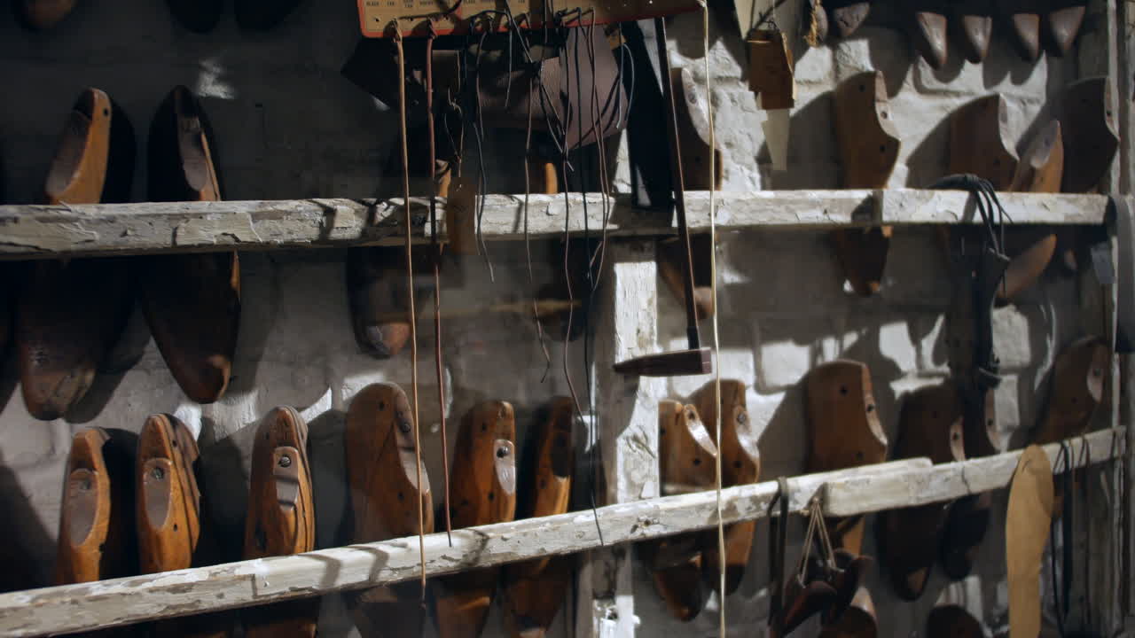una pared de hormas de zapatos vintage en un taller de zapatería