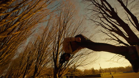 person performing parkour in a park at sunset