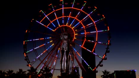 Statue of Ali and Nino on a background Ferris wheel at night on the embankment of Batumi, Georgia
