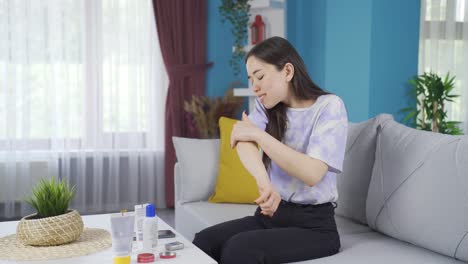 Young-Asian-girl-applying-cream-to-her-painful-areas.