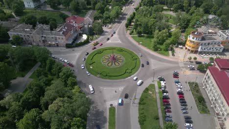 4k aerial view of roundabout road with circular cars in small european city at sunny day