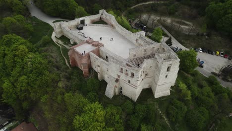 Slowly-tilt-dolley-view-of-Kazimierz-Dolny-Castle-in-Poland-between-green-trees