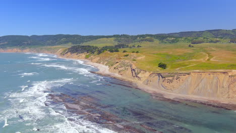 the white cliffs and rolling grassland hills of rca beach in california - aerial flyover