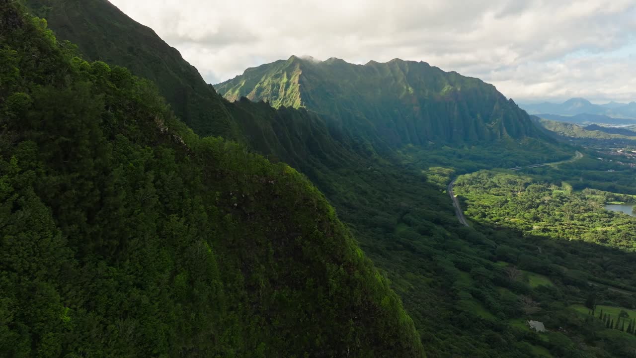 Nu'uanu Pali Lookout as seen by Drone, Breathtaking Aerial View of Ko'olau Cliffs in Oahu Hawaii, Daytime Aerial Footage over Lush Green Mountains with Stunning Ridgelines and Winding Road