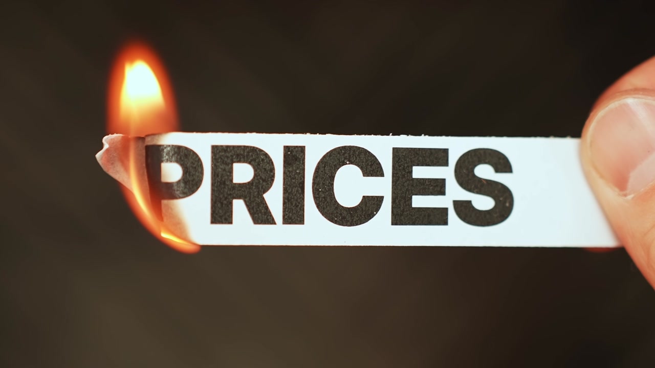 Burning “PRICES” concept symbolizing falling costs, easing inflation, discounts, affordability, and improved consumer spending power.