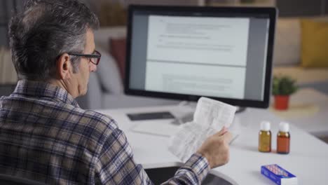 hombre enfermo leyendo el prospecto del medicamento.