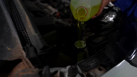 detailed shot of a mechanic pouring windshield cleaning liquid to fill the tube of a car, 4k