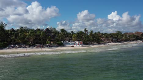 Right-to-left-aerial-pan-shot-of-tropical-beach-with-exclusive-tourist-resort