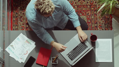 Von-Oben-Nach-Unten-Porträt-Eines-Geschäftsmannes-Bei-Der-Arbeit-Im-Büro