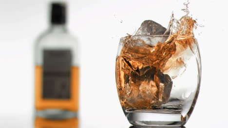 ice cubes in super slow motion falling in a glass of whiskey