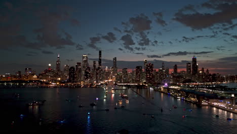 AERIAL:-boat-traffic-on-Lake-Michigan-with-Chicago-skyline-background,-moody-dusk