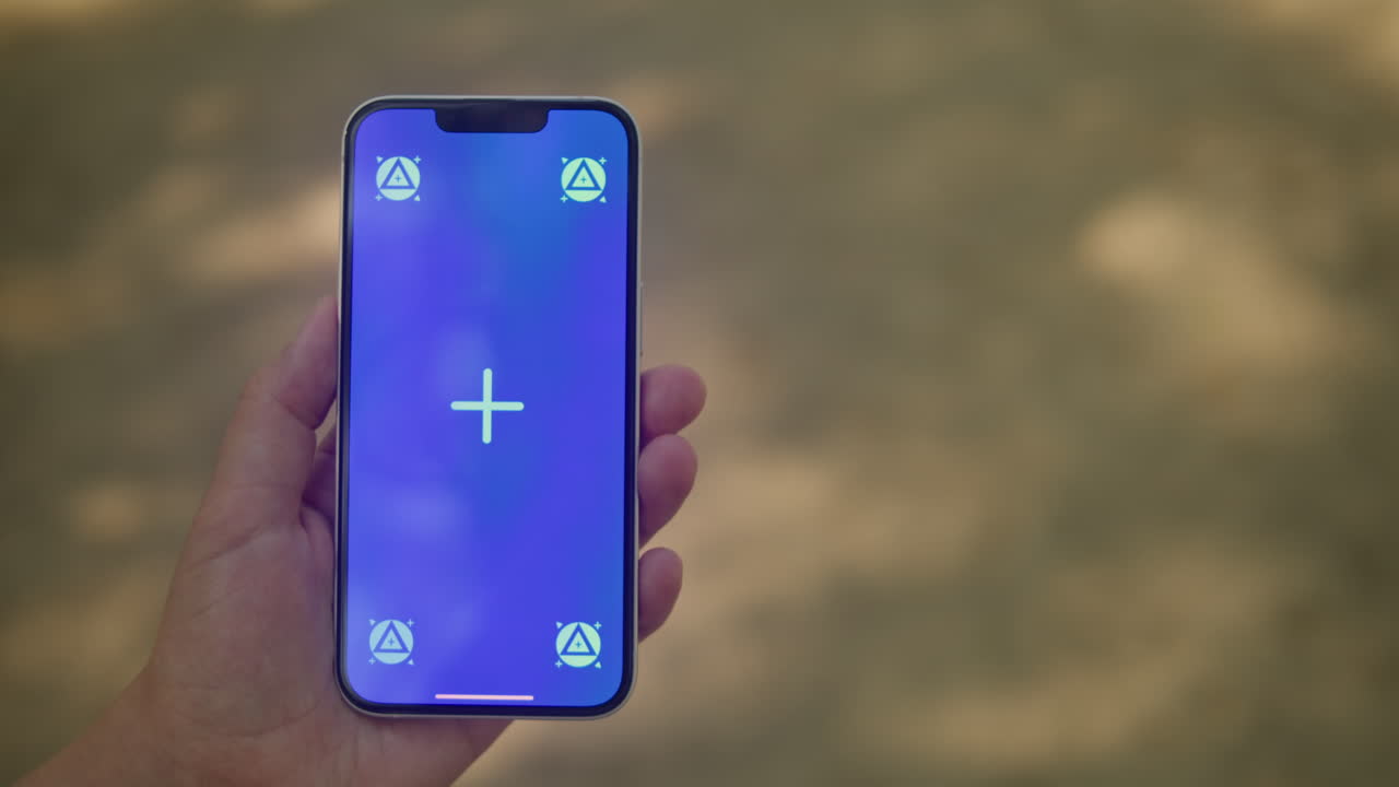 Young woman holding phone chroma key screen in front of sand background close-up. Girl with green screen on smart phone. Nature