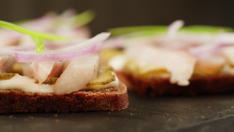 appetizer sandwiches with smoked fish, pickles, and onions