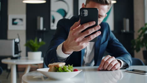 man taking a picture of his lunch with his phone