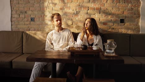 couple sitting at a table in a cafe and drinking tea