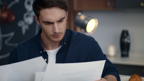 hombre de negocios enfocado mirando diagramas en la oficina de casa. hombre leyendo documentos