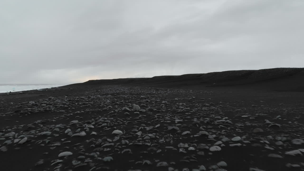 Rocks and Black Volcanic Sand Beach on Coast of Iceland, Aerial View, Low Angle