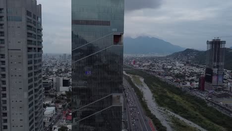 Gran-Edificio-Sobre-Una-Gran-Avenida-Con-Muchos-Autos-Circulando