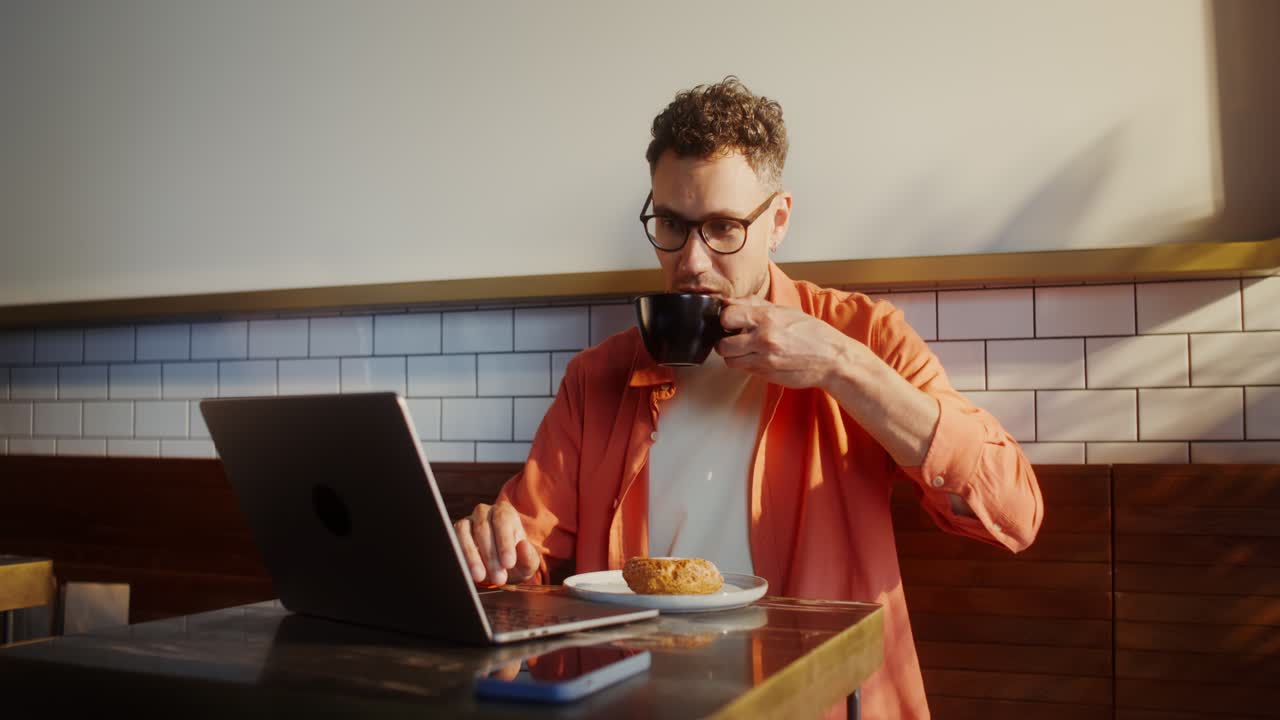 Man Working on Laptop in Cafe