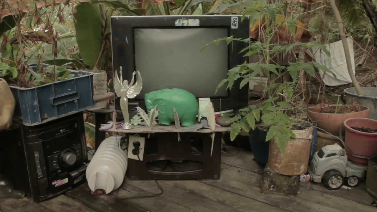 Medium shot of decorative waste with broken tv at a Darien Gap rustic house in Colombia.
