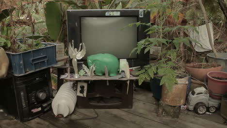 medium shot of decorative waste with broken tv at a darien gap rustic house in colombia.