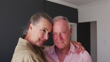 Caucasian-senior-couple-embracing-each-other-at-home