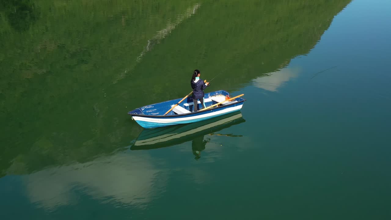 la mujer en el barco atrapa un pez en el giro en noruega.