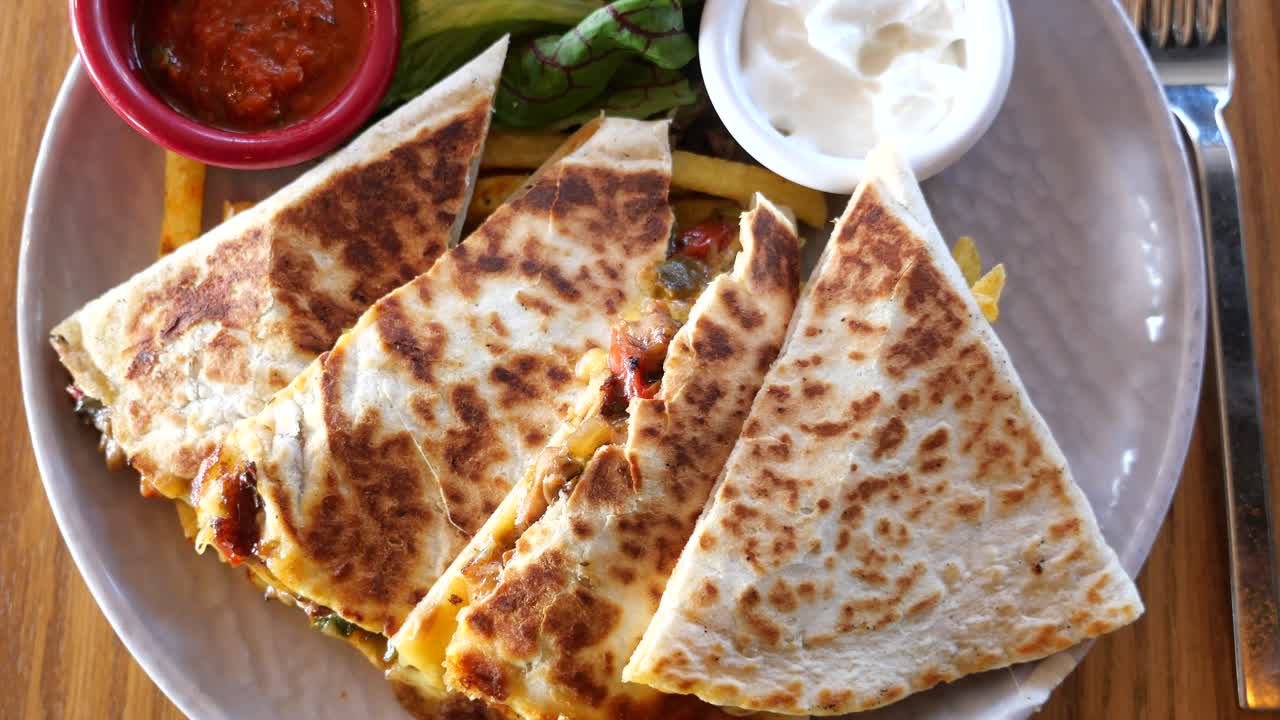 quesadilla con salsa, crema agria y ensalada