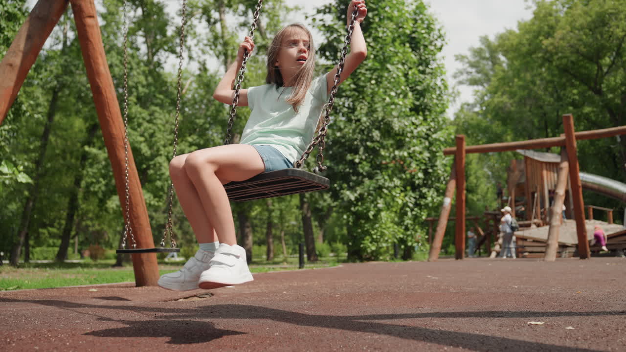 Bambina energica si diverte spensierata sull'altalena all'aperto. Una giovane ragazza gioiosa sperimenta la libertà mentre si dondola felicemente al parco. Una bambina vivace esprime pura delizia mentre si libra gioiosamente nell'aria sull'altalena