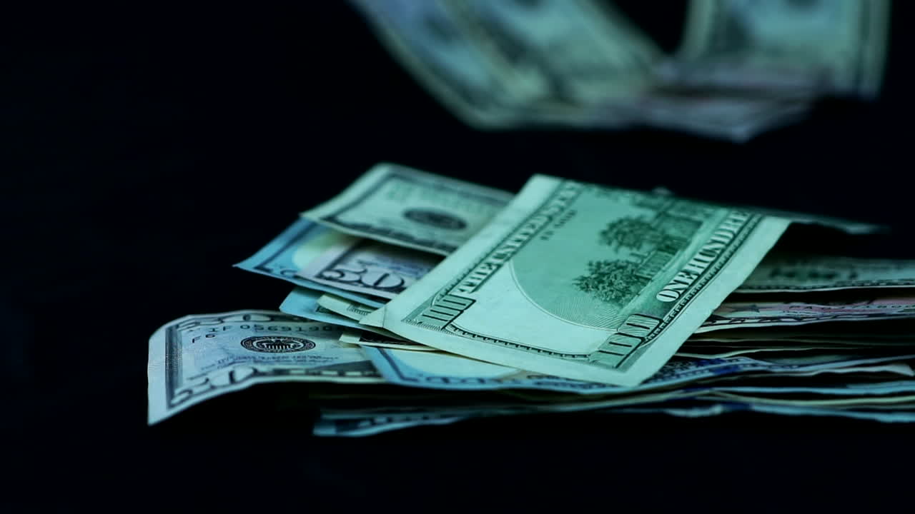 montón de moneda dólar cayó contra la superficie negra