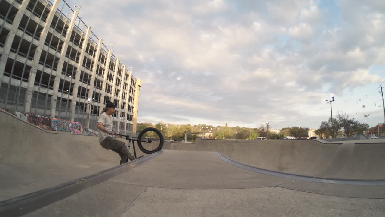 bmx 자전거 라이더는 스케이트 파크 공원 위에 엄청난 조정 공기를합니다. 극심한 800fps 느린 동작, 4k 물고기 눈, 자전거 트릭, 해가 뜨는 시점.