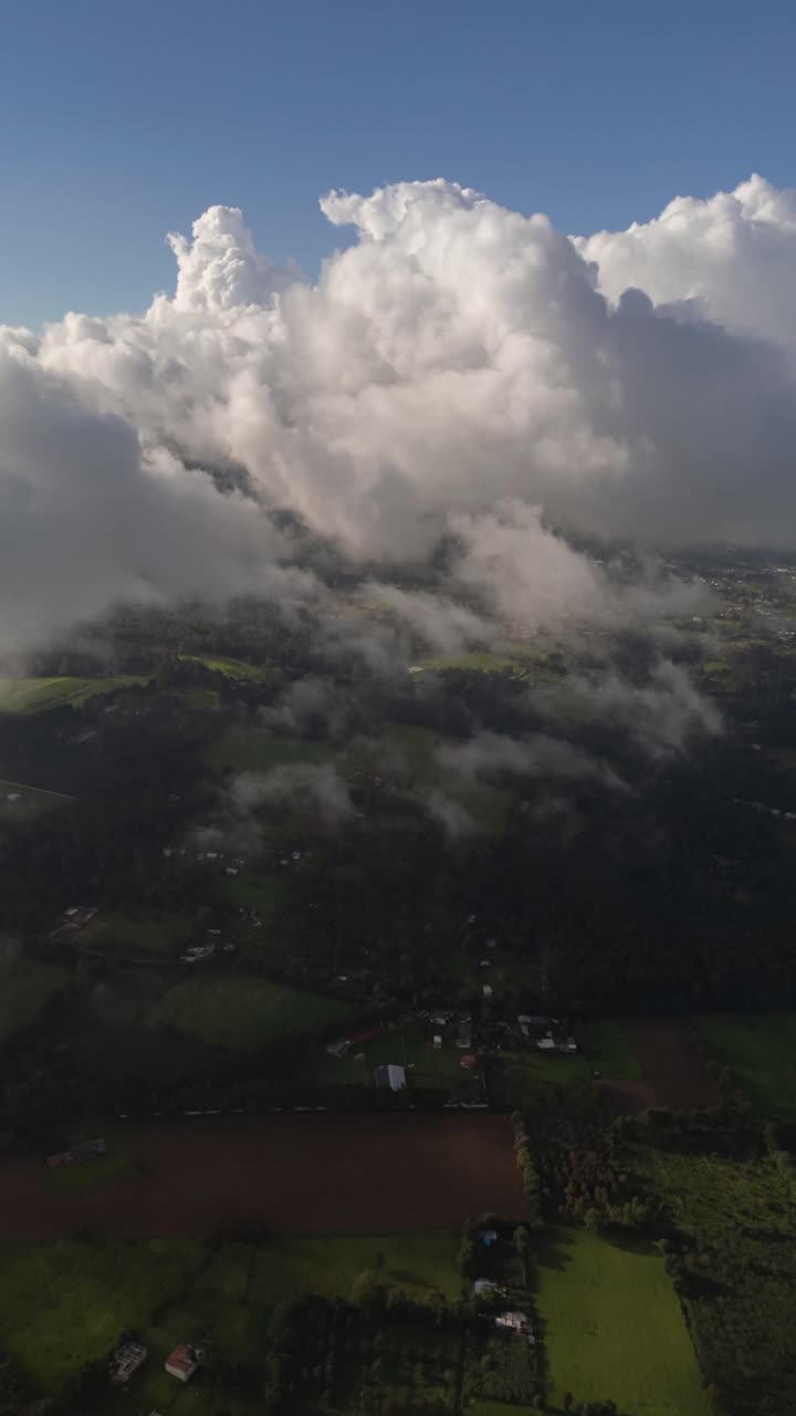 Vertical time-lapse shows clouds drifting above a natural landscape with dynamic sky motion.