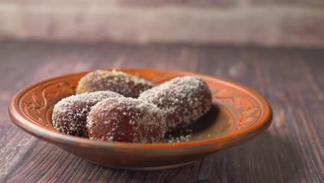 Hand-pick-indian-sweet-in-a-bowl-on-table