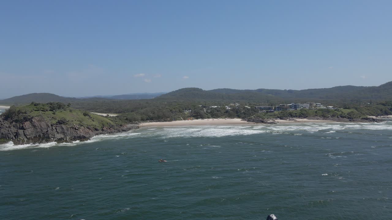 drone volando sobre el mar de coral hacia la playa de cabarita en nueva gales del sur, australia