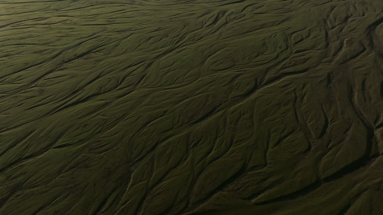 volando sobre las trenzas del río glaciar islandia, panear hacia arriba para revelar el glaciar