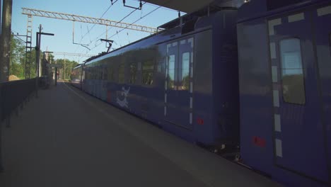railway platform and a passing blue train