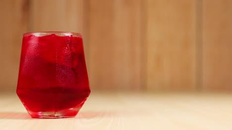 a red drink in a glass on table