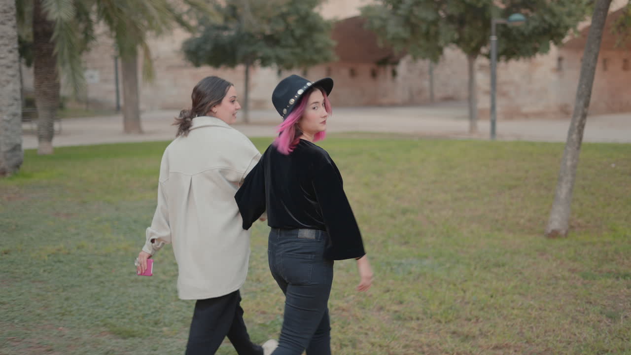 две женщины гуляют в парке.