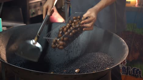 Primer-Plano-Del-Famoso-Mercado-Nocturno-De-Taiwán,-Primer-Plano-De-Castañas-Asadas-Profesionales-En-Arena-Con-Azúcar-Morena-A-Altas-Temperaturas-Con-Humos-Aromáticos