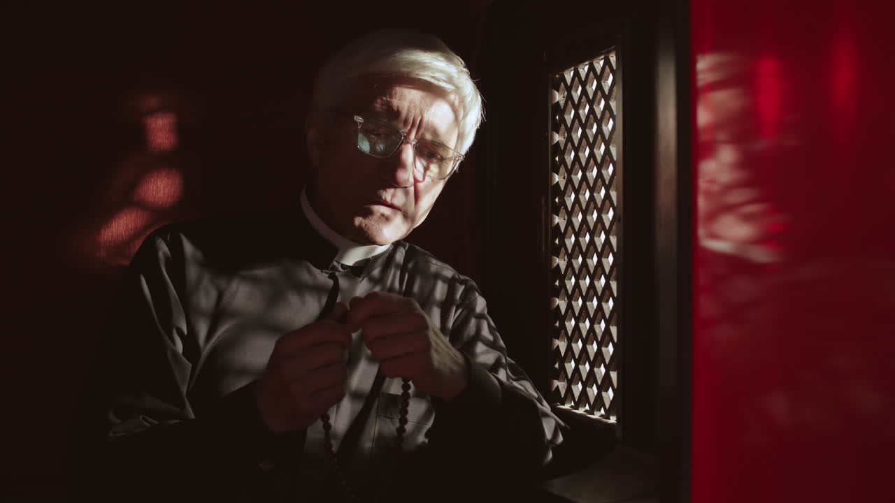 Senior Pastor Sitting in Confessional Booth