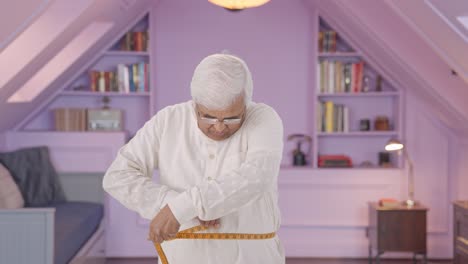 anciano indio midiendo la cintura usando cinta de pulgada
