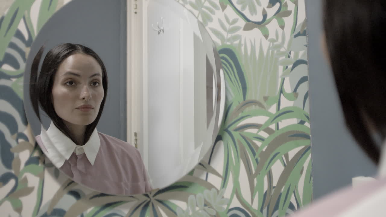 beautiful latina girl getting dressed in her bathroom and looking at herself on the mirror