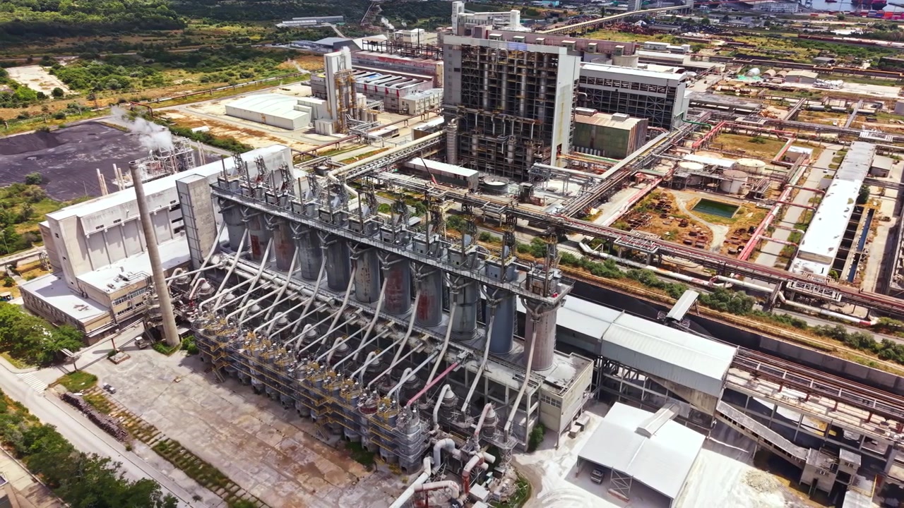 Industrial plant located in a large manufacturing area showing various structures and machinery in operation during daytime